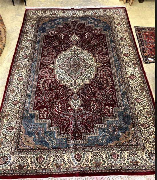 A Persian style burgundy ground small carpet 281 x 183cm